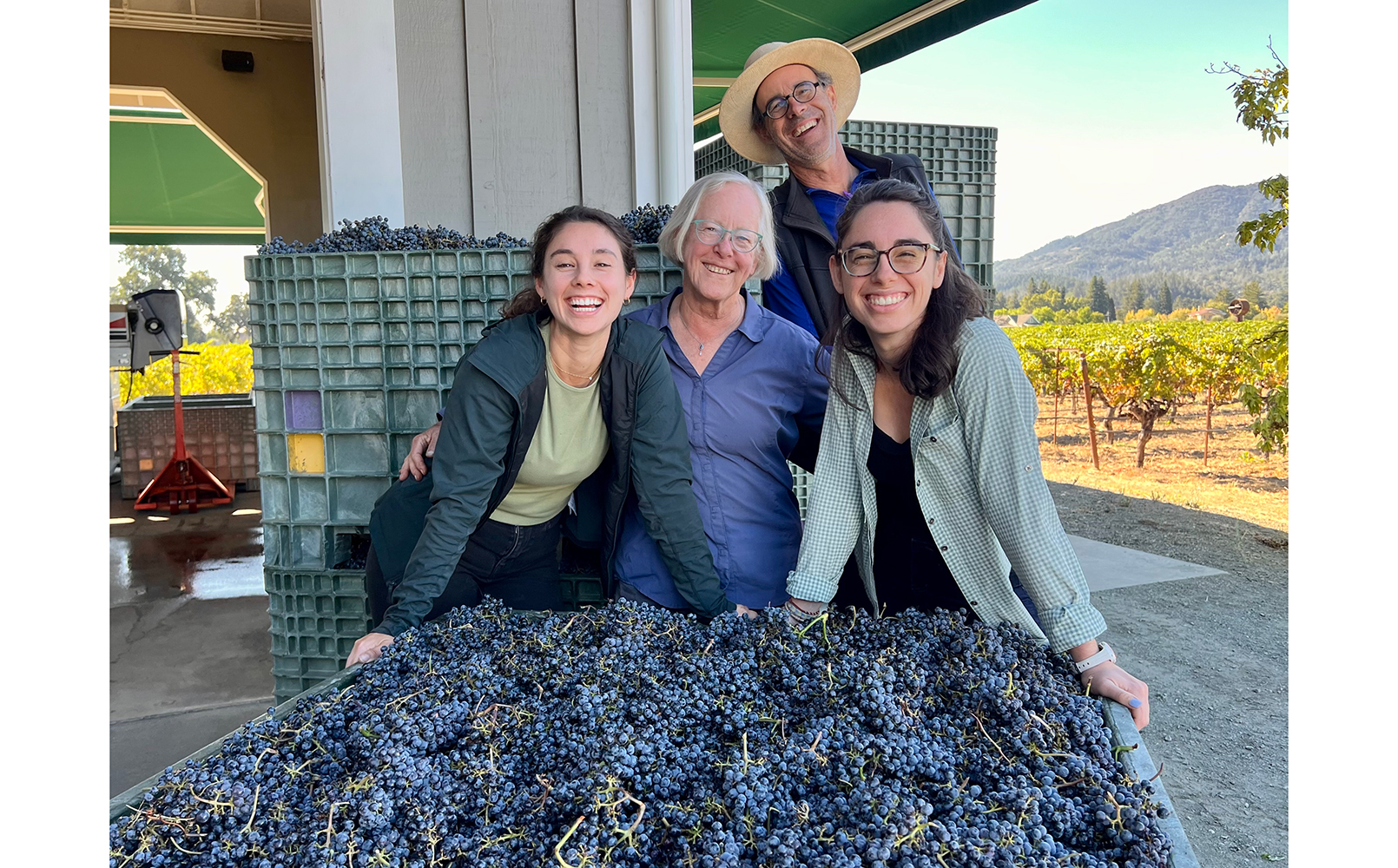 Grace, Cathy, William and Rose Corison Martin on the winery crush pad with a bin of grapes