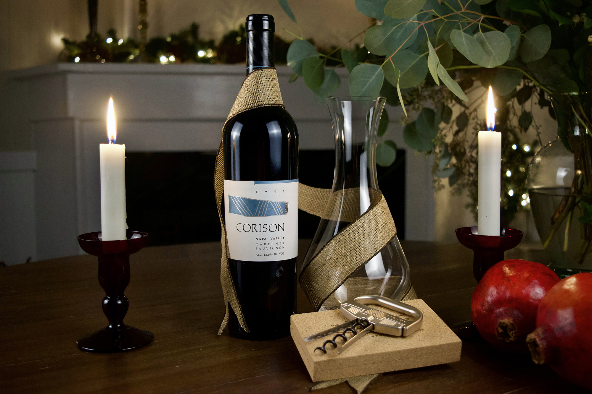 A bottle of 1991 Corison Cabernet Sauvignon with a decanter and durand wine opener with holiday decorations.